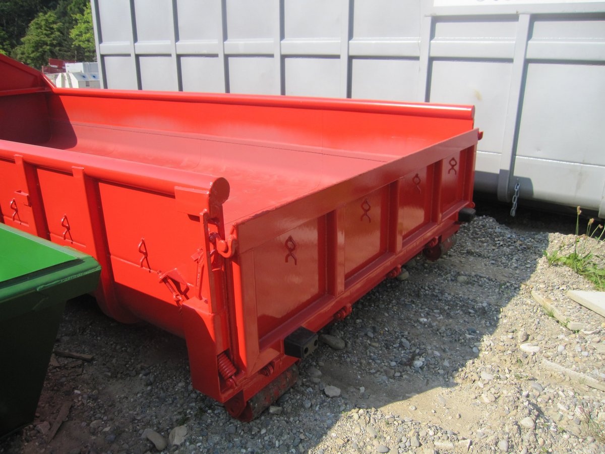 Abrollcontainer mit Schuttmulde in Rot und integrierter Rampe zur einfachen Beladung